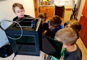 Uczniowie na zajęciach "Programowanie z elementami robotyki" poznają działanie i mozliwości drukarki 3D.