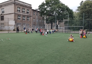 Integracyjne zabawy pierwszoklasistów na szkolnym pikniku.