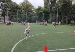 Integracyjne zabawy pierwszoklasistów na szkolnym pikniku.