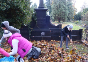 Uczniowie sprzątają na cmentarzu.