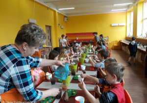 Uczniowie kolorują ceramiczne figurki.