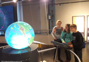 Uczniowie oglądają interaktywny globus.