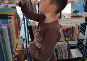 Uczeń w trakcie szukania książki.