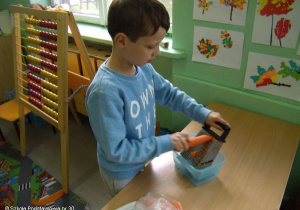 Uczeń kl.2a ściera marchewkę.